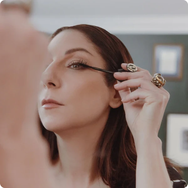 A woman applies mascara using the lash wrap ergonomic mascara
